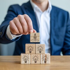 Person in blue suit placing wooden block with rocket on of a pyramid of light bulb blocks wooden blocks