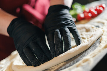 Skilled hands shaping pizza dough in artisanal pizzeria setting