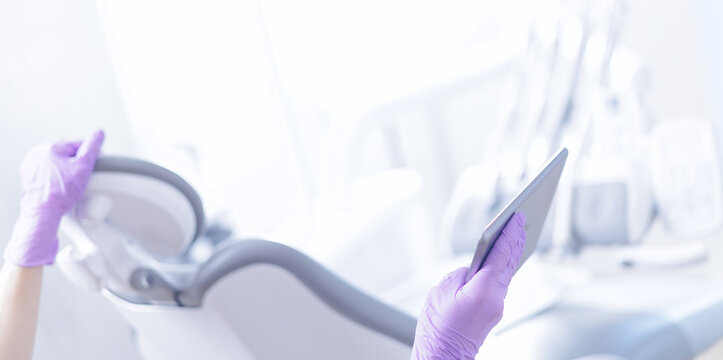 Dental office exam room with purple-gloved hands using tablet for patient records with mri scan - Powered by Adobe