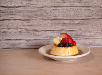Imagen horizontal de un flan napolitano con frutos rojos y manzana