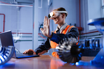 Caucasian male adult using vr technology in industrial setting with laptop computer on industry workplace
