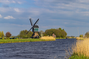 Naklejka premium Dutch windmill standing by canal in Brandwijk, Netherlands