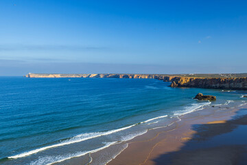 Algarve coastline with long sandy beach and ocean waves