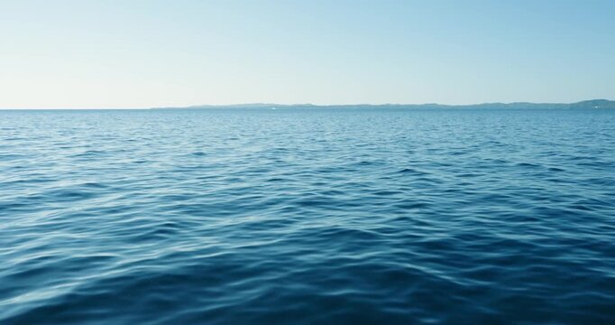 Sailing over blue ocean seascape with water waves texture at coast of Greece
