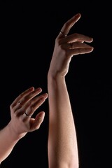 Elegant woman's arms with wet skin and goosebumps on black background