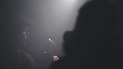 Photographer take photos of sommelier describing taste of red wine backlit by cinematic light scene. Degustation of alcoholic beverages, slow motion