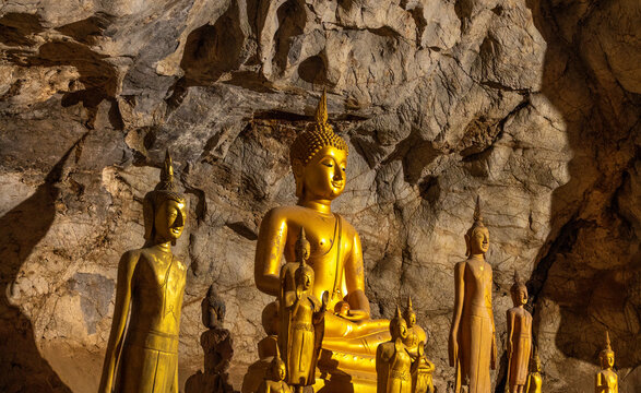 Mesmerizing view of ancient golden buddha sculptures in the hollows of the Tham Tring cave (upper cave) of the Pak Ou Caves at the confluence of the Ou and Mekong rivers, Luang Prabang, Laos