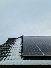 Solar panels generating clean energy during winter snow © Michael