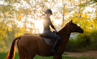 A young girl riding a chestnut horse in rural countryside.