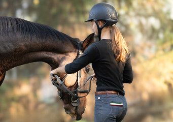 Young girl preparing horse for ride