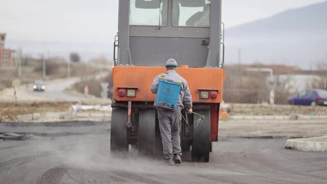 Industrial road construction site with rollers that rolls a new asphalt in the roadway, slow motion