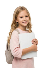 Obraz premium A girl stands holding a school book with a backpack on her back and smiles.