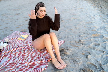 Young woman enjoying mindfulness meditation on winter beach