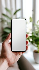 Hand holding smartphone with blank white screen