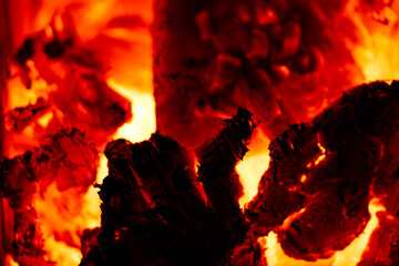 Burning wood logs glowing red in fireplace