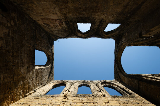 Gothic arches framing blue sky in the sunlit ruins of Oybin Monastery, part of the castle complex on Oybin mountain in Saxony, Germany