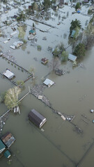 Aerial drone footage of a massive city flood with houses and streets submerged under water. Urban flooding caused by extreme weather and heavy rainfall, showing natural disaster impact on residential 