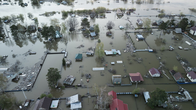 Aerial drone footage of a massive city flood with houses and streets submerged under water. Urban flooding caused by extreme weather and heavy rainfall, showing natural disaster impact on residential 