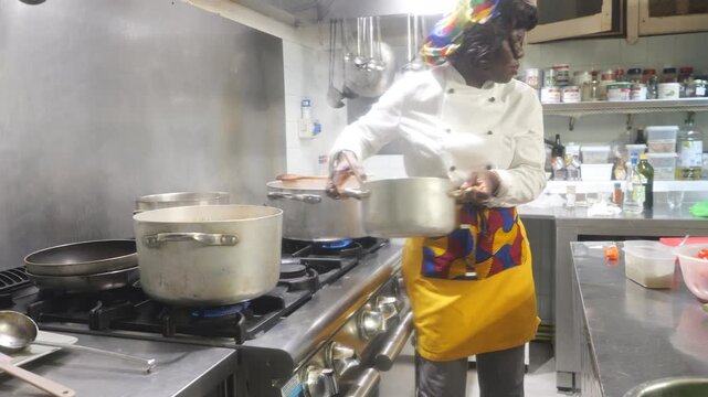 Chef in a professional kitchen preparing a meal with multiple pots on the stove