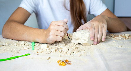 Young artist carves a stone sculpture at a table during a craft workshop