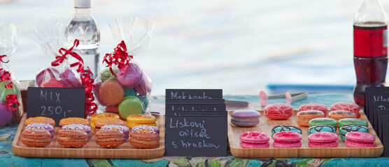 Vibrant seaside market display features colorful macarons and sweet treats, gift bags and...
