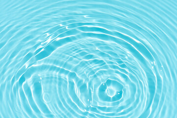Blue water with ripples on the surface. Defocus blurred transparent blue colored clear calm water surface texture with splashes and bubbles. Water waves with shining pattern texture background.