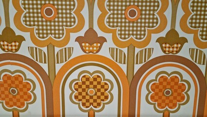 Bright floral pattern with geometric design in orange and brown tones on wall decor from a retro setting