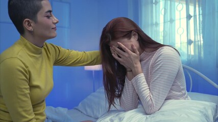 One woman comforting another who is crying, showing empathy and emotional support in a calm and intimate home setting