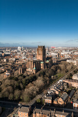 Fototapeta premium Aerial sunrise view of Liverpool with Liverpool Cathedral, winter trees, brick terraces, River Mersey, Radio City Tower, docks, wind turbines, and Albert Dock area.
