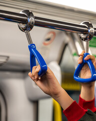 two passengers holding blue subway handles inside a metro train. urban public transport concept showing daily commute, safety, balance and modern city mobility