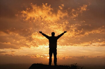 Fototapeta premium Person standing with arms open at sunset celebrating freedom