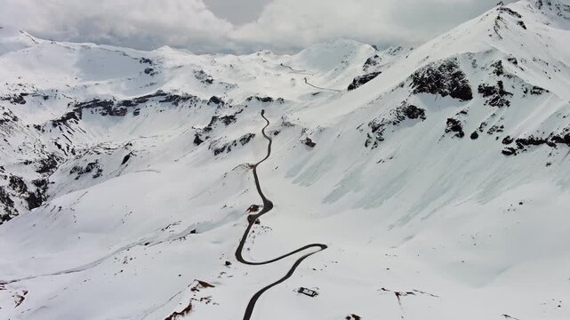 Aerial view of Grossgloknershtrasse in snow. Great high mountain road near Grossglokner mount in Austrian Alps, 4k