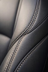 Fototapeta premium An up-close view of a black leather interior, with prominent stitching and perforated detailing.