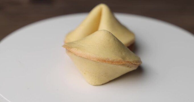 Traditional Asian fortune cookies in 360 rotation. The dark background highlights the golden color of these iconic crispy treats for holiday clips.
