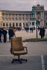 Discarded worn office chair abandoned in a Vienna city square, c