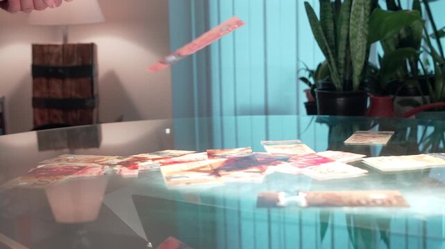 Canadian currency falling in slow motion on a glass dining table