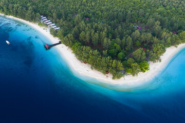 A remote island resort lies on a beautiful island in the midst of the Dampier Strait in Raja Ampat, Indonesia. The extensive, surrounding coral reefs are full of fish and sometimes feeding manta rays.