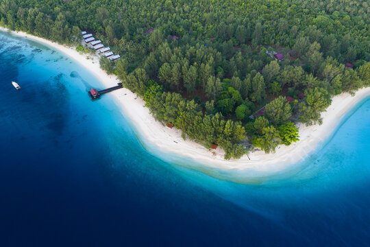 A remote island resort lies on a beautiful island in the midst of the Dampier Strait in Raja Ampat, Indonesia. The extensive, surrounding coral reefs are full of fish and sometimes feeding manta rays.