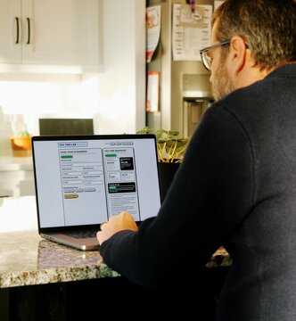 Middle Aged Man Runs Tax Assessment for Home Based Small Business Preparing for Tax Season and Prepayments Concept