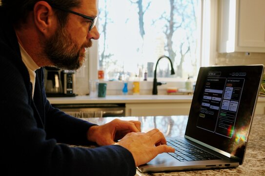 Middle Aged Man Runs Tax Assessment for Home Based Small Business Preparing for Tax Season and Prepayments Concept