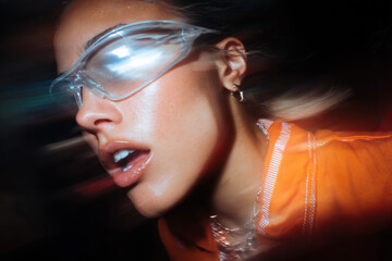 Woman wearing sunglasses enjoying Y2K nightclub fashion street style