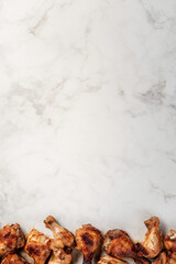 Fried chicken pieces on white marble background with copy space