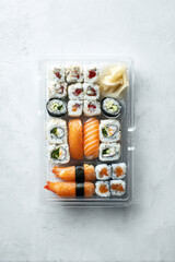 Assorted sushi platter in clear plastic tray, sushi takeaway/ delivery concept. 