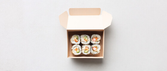 Open cardboard box with assorted sushi rolls top view