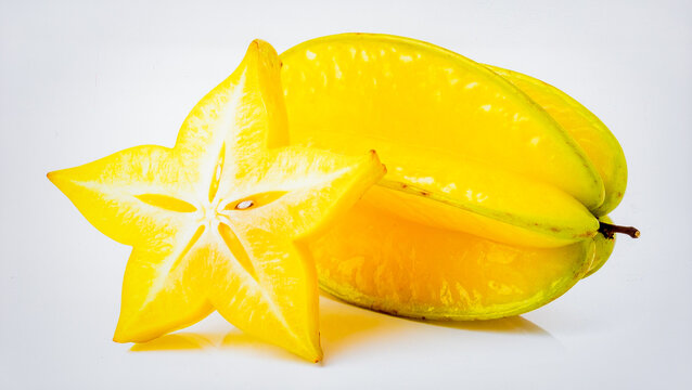 Fresh carambola (star fruit) with waxy skin and star shape, isolated on pristine white background.