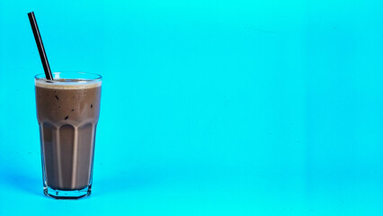 Cold Chocolate Milkshake in Glass with Straw Isolated on Blue Background for Beverage Dessert Object and Refreshing Drink Concept