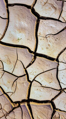 Dry clay surface with natural cracks forming abstract geometric texture pattern
