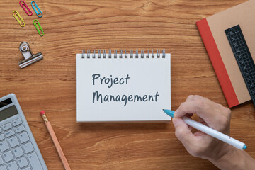 There is notebook with the word Project Management. It is as an eye-catching image.