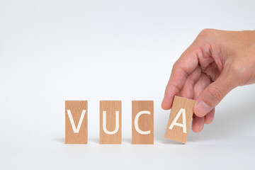 There is wood block with the word VUCA. It is an abbreviation for Volatility, Uncertainty, Complexity, Ambiguity as eye-catching image.