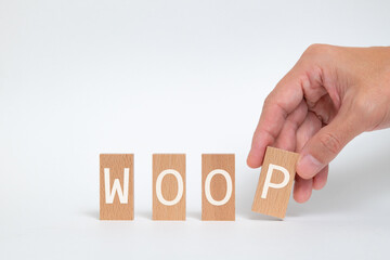 There is wood block with the word WOOP. It is an abbreviation for Wish, Outcome, Obstacle, Plan as eye-catching image.